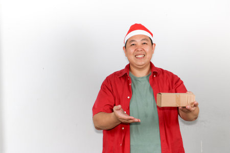 Happy delivery man with a Santa hat holding packages for Christmasの写真素材