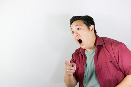 asian fat man pointing at camera on white background, copy spaceの写真素材