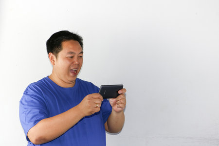 Asian man using mobile phone isolated on white background with copy space.の写真素材
