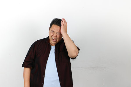 Asian guy holding his head having headacheの写真素材