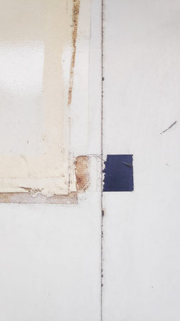 Old white paint on the wall of a building. Abstract background.