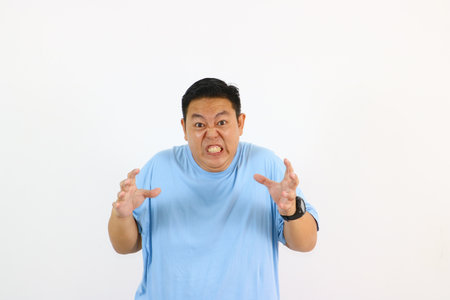 Angry man showing teeth with hands raised in front of himの写真素材