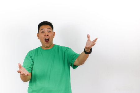 A surprised Indonesian male with a genuine look of wonder, reacting to an unexpected event with excitement.の写真素材