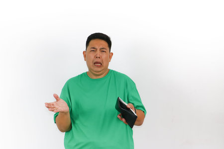 An Asian man is crying and extremely sad, counting money in his wallet with a look of despair and...