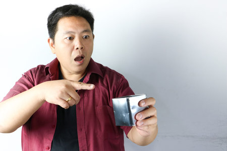 Asian Man in short sleeve red shirt expressing joy and surprise with his hands gesture and excited attitude on white background.の写真素材