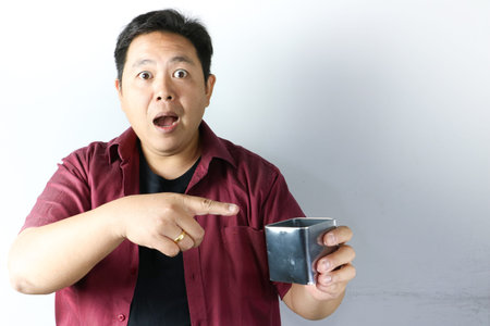 Asian Man in short sleeve red shirt expressing joy and surprise in the open container with his hands gesture and excited attitude on white background.の写真素材