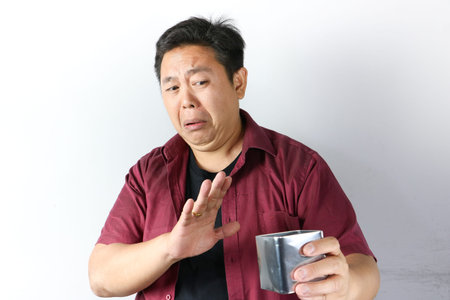 Isolated studio shot of a man with dark hair, red shirt, and a black t-shirt underneath, expressing...