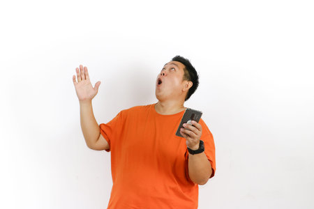 Man expressing satisfaction after hearing good news or an amazing fact on his phone, hand raised in...