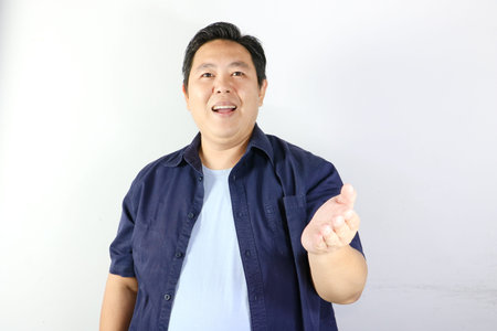 Cheerful handsome Asian man offering a helping hand with a welcoming facial expression