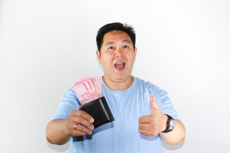 photo of asian man looks delighted while showcasing his wallet for finances freedom and cash savings...
