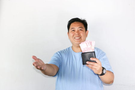 photo of asian man looks delighted while showcasing his wallet for finances freedom and cash savings...
