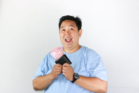 photo of asian man looks delighted while showcasing his wallet for finances freedom and cash savings...