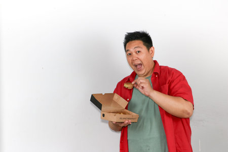 Excited asian man holding an open box of traditional indonesian sweet martabak pancakeの写真素材