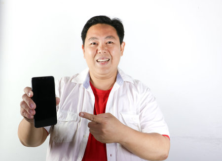 Cheerful Indonesian man celebrates independence day while wearing a patriotic red and white headbandの写真素材