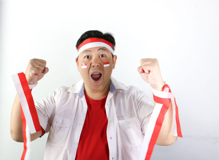 Cheerful handsome Asian man showing wow expression and happiness gesture to celebrate Indonesia Independence Day.の写真素材