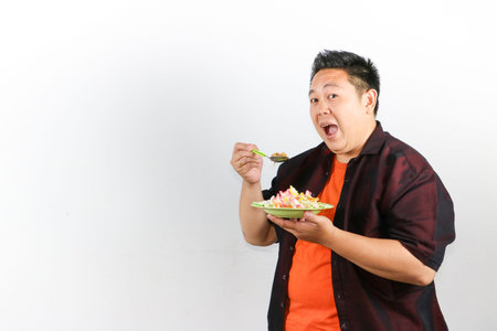 Happy Asian man eating authentic Indonesian fried rice, authentic Southeast Asian food and travel...