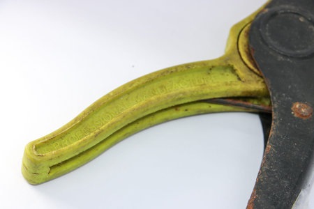 Old self adjusting wire stripper tool with yellow plastic handles and rusty metal parts