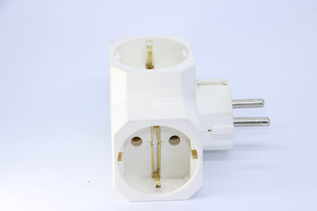 White three way electrical plug adapter isolated on a clean white background for industrial use