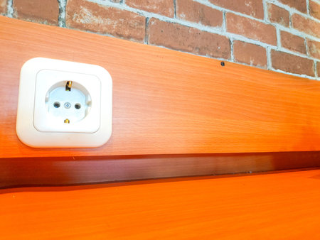Modern white electrical outlet featuring two round pin holes and ground contacts