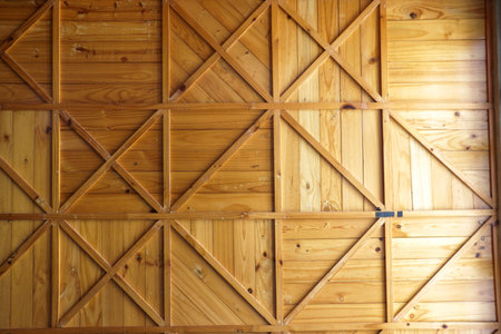 Decorative wooden ceiling featuring a symmetrical X brace pattern and natural pine wood planks