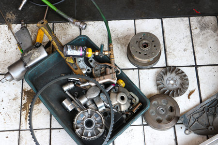 Close up of worn CVT rollers and metal pulley components during a routine motorbike transmission...