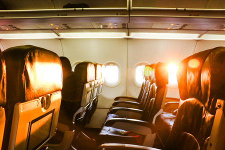 Comfortable economy class airplane seats are arranged in a three unit row in the cabin