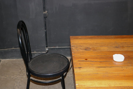 A stylish black iron cafe chair features a modern industrial design for outdoor dining