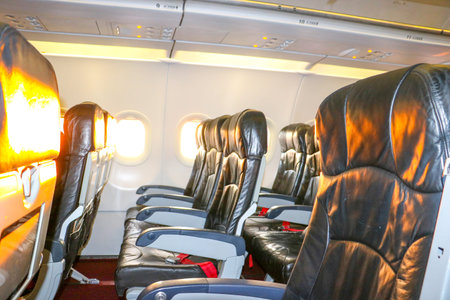 Comfortable economy class airplane seats are arranged in a three unit row in the cabin