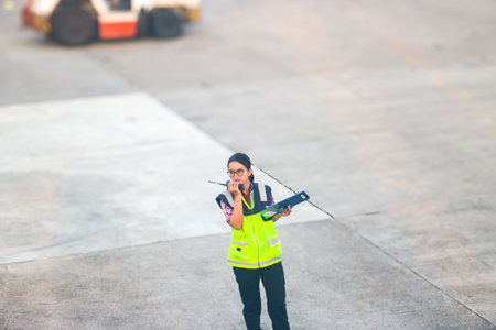 Ground staff member communicating via walkie talkie at the airport apron during daily operations....