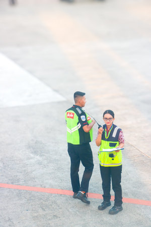 Airport staff in safety gear managing ground services at the terminal apron. Bali, Indonesia 20 May...