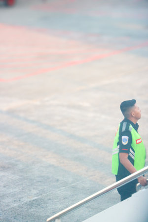 Airport staff in safety gear managing ground services at the terminal apron. Bali, Indonesia 20 May...