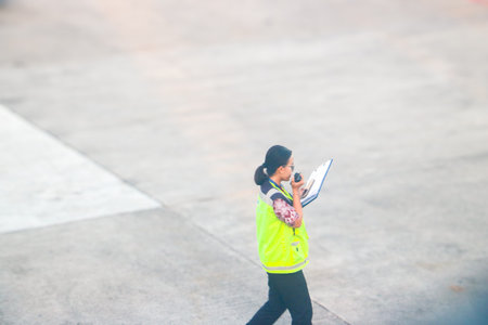 Ground staff member communicating via walkie talkie at the airport apron during daily operations....