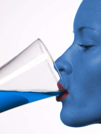 Young beautiful girl drinking a cocktail, futuristic colourの写真素材
