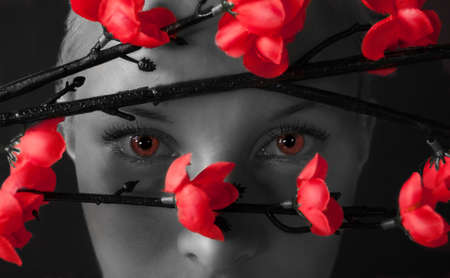 Young beautiful girl watching through bushes, vamp lookの写真素材