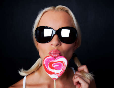 Young sexy woman kisses her candyの写真素材