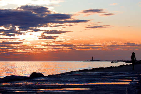 Beautiful fall sunset on the beach near pier and lighthouseの写真素材