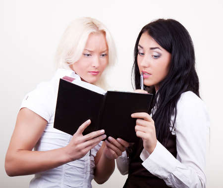 Portrait of two  young pensive businesswomen in office, blonde and brunette.の写真素材