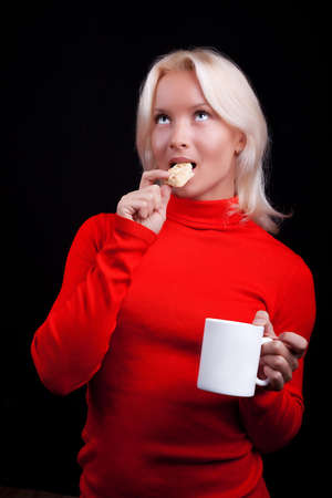 Attractive playful blonde drinking tea with cookiesの写真素材