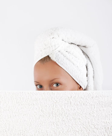 Closeup portrait of attractive young blonde hiding behind towel after bath の写真素材