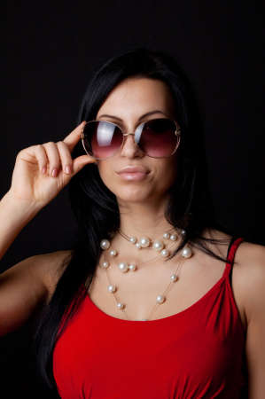 Portrait of sexy brunette in red dress wearing sunglassesの写真素材