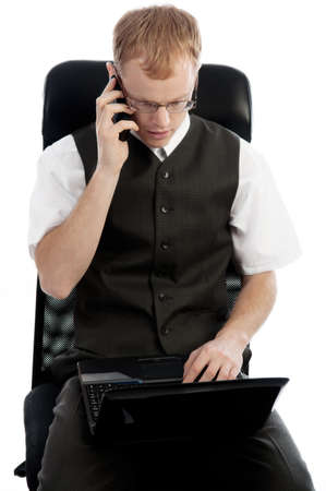 Successful business man calling on the mobile and looking at the laptop の写真素材