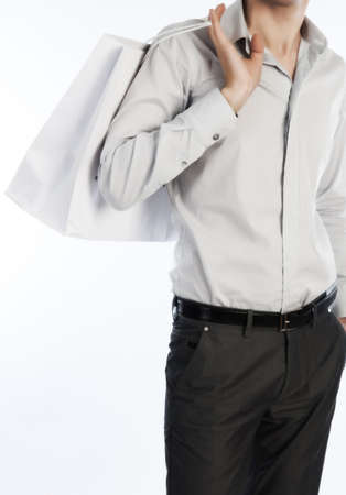 Young slim metrosexual with white shopping bagの写真素材