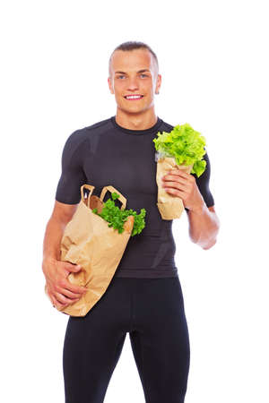 Portrait of strong man posing in studio with saladの写真素材