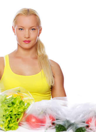 Portrait of sexy woman posing on the kitchen with vegetablesの写真素材