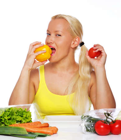 Portrait of beaty woman eating vegetables on the kitchenの写真素材