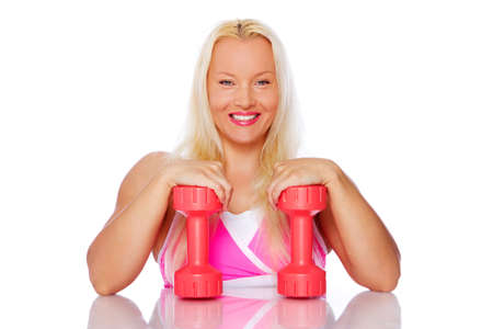 Portrait of smiling woman posing in studio with dumbbellsの写真素材