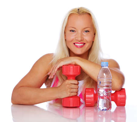 Portrait of smiling woman posing in studio with dumbbellsの写真素材