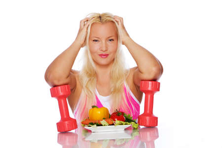 Portrait of sexy woman posing in studio with vegetablesの写真素材