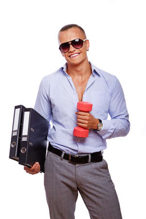 Portrait of handsome man posing in office with folders and dumbbellsの写真素材