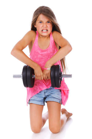 Portrait of strong girl posing in studio with dumbbellsの写真素材